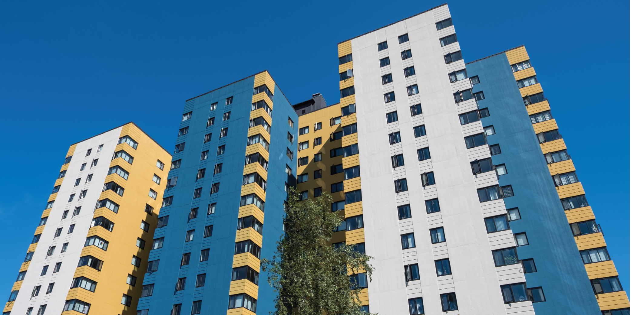 Up angle of a blue, yellow and white high-rise apartment building